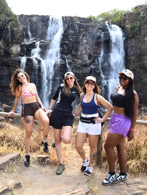 Quatro amigas posando em frente à cachoeira do Salto de Corumbá